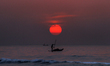 A Palestinian fisherman on his small boat to fish during sunset off the coast of Gaza City...