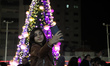 A Palestinian girl takes a selfie in front of a Christmas tree in Gaza City on December 10...