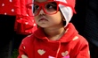 A girl child dressed in a Santa Claus spends time near a Church on the day of Christmas fe...