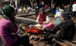 A vendor prepares paan, a betel nut-based chewable stimulant, as he sits on a hand cart us...