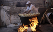 Inhabitant of San Francisco Culhuacán in Mexico City, places tamales in a pot to be cooked...