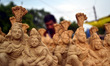 An indian potter sets  idols of Lord Shiva and Goddess Parvati, in his trolly to sell,on t...
