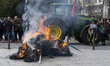 Some Farmer observe the remains of a bonfire that they lit during the protest of the ranch...