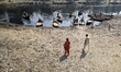 A man goes to cross the dried-up, polluted Buriganga river on March 13, 2022, in Dhaka, Ba...