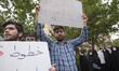 An Iranian man holds-up a placard during a protest gathering in front of the Sweden Embass...