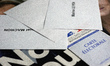 A voter registration card is pictured with a 'Macron' and a 'Le Pen' ballot papers.  Many...