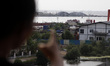 A local resident shows the location of coal activity in Marunda port from the flats, in No...