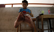 A boy show his feet which looks black after walking on the floor, due to coal dust polluti...