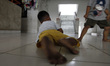 A boy's feet looks black while he playing with his friend on the floor of a flat, due to c...