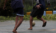 Boys playing soccer with feet that look black from coal dust at Marunda flat, North Jakart...