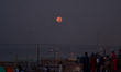 Indian people watch super moon on the banks of River Yamuna,in Allahabad on September 28,2...
