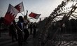 Protesters standing near barbed wires  raising Bahrain flags during Tamarod rally day 2 ,...