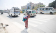October 2, 2015, Kathmandu, Nepal -- People cross the roads as the vehicials line up to fi...