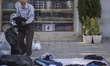 An Iranian elderly vendor puts clothes on the floor near a shopping center in the Ekbatan...