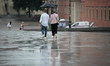 A man and a woman are seen walking with an umbrella near the Royal Castle in Warsaw, Polan...