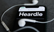 Heardle logo displayed on a phone screen and headphones are seen in this illustration phot...