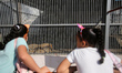 Palestinian children look at lions sitting inside a cage at nama zoo in Gaza city on July...
