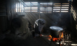 A Palestinian mother uses wood fire to prepares a cow tripe for her family, in Beit Lahia...