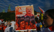 A protester holding a poster with an image of the  Belarusian leader with words 'Stop Call...