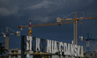 A partial view of the historic gate of Gdansk shipyard number 2 and construction cranes, s...