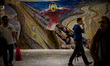 People passes in front of a painted mural during the XXI Edition of  Manga Fair (Salo del...