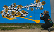 A young women takes a photo of a pro-Ukrainian mural created by Polish artist Maja Krzyzyn...