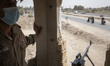An Iraqi armed military personnel monitors an area while Iraqi Shi'ite pilgrims walking al...