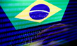 Flag of Brazil displayed on a laptop screen and binary code displayed on a screen are seen...