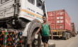 A truck driver carries a bucket of water to his vehicle at the clossed border crossing bet...