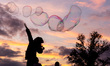 Children play with soap bubbles by the Vistula River in Old Town of Krakow, Poland on Octo...
