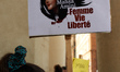 A woman holds a drawing of Mahsa Amini with the words 'Women, Life, Freedom'. A protest ma...