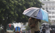 Residents make their way during a heavy rainfall in Dhaka, Bangladesh as the effects of Cy...