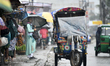 City dwellers make their move during a heavy rainfall in capital Dhaka on October 24, 2022...
