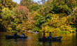 People are swimming on boats on The Lake during fall in Central Park in New York, United S...
