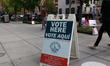 People attend in-person early voting at the West End Public Library in Washington, D.C. on...