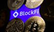 BlockFi logo displayed on a phone screen and representaation of cryptocurrencies are seen...
