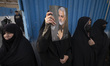A veiled Iranian protester holds-up a portrait of former Iranian commander of the Islamic...