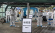 Workers dress in Personal Protective Equipment at a monitoring area during a government ex...