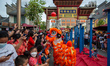 People touch the head of a dancing lion to pray for good luck at Old Shanghai, China Town...