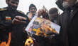 Iranian worshippers burn a portrait of the French President Emmanuel Macron, in a protest...