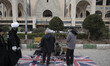 Some men wax the shoes of Iranian worshippers on Britain flags during Tehran's Friday pray...