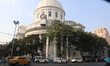 

A yellow Ambassador taxi is passing the Heritage Building GPO in Kolkata, India, on Febr...