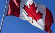 Canadian flag flutters against a blue sky in Richmond Hill, Ontario Canada, on February 11...