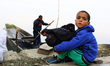 Adnan, 5, sits on the banks of Wular Lake as his parents are busy with collecting dry wate...