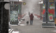 KYIV, UKRAINE - MARCH 12, 2023 - A person walks a dog as it is snowing in early spring, Ky...