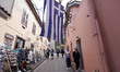 Tourists walk past a giant greek flag in athens on 22 March 2023. 