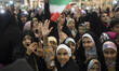 Veiled Iranian schoolgirls hold-up their hands as a reaction to a religious song during th...
