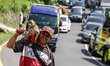 A man with his monkey poses for photo while stuck in a traffic jam ahead of Eid al-Fitr ho...