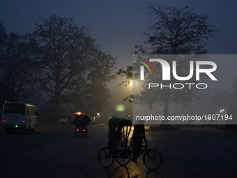 An indian rickshaw puller waits for passengers at district bus statioon  during a cold and rainy morning in Allahabad on January 19,2016.A c...