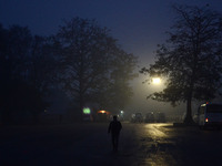 An indian passenger walks at District bus station to catch his bus ,during a cold and rainy morning in Allahabad on January 19,2016.A cold w...